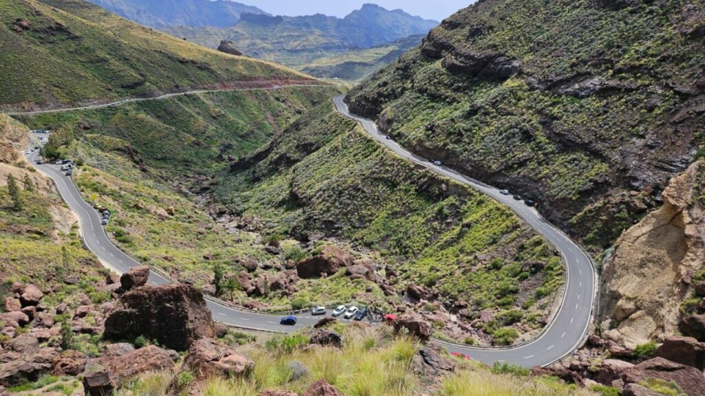 Hairpin bends and cars parked along the road at Fuente de los Azulejos