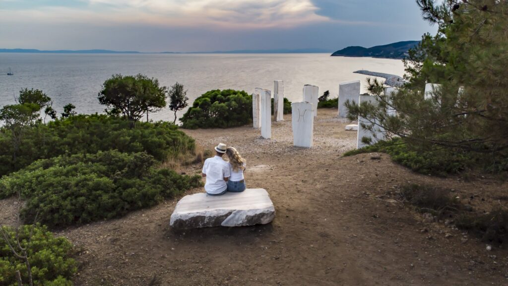 A couple at sunset by the marble zodiac above Metalia beach near Limenaria, Thassos